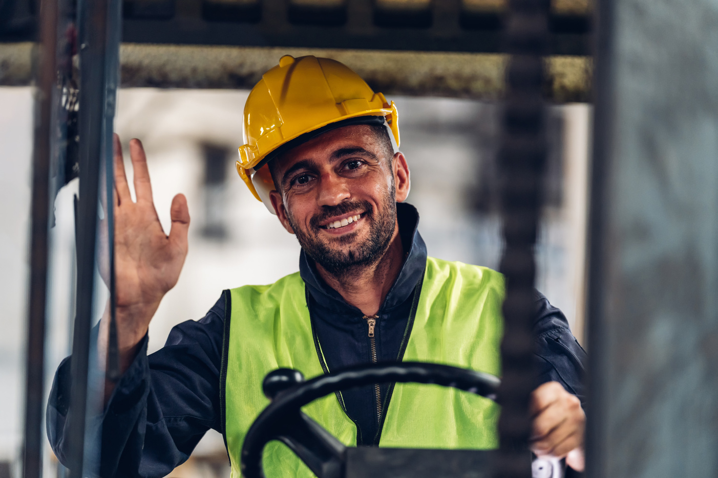 Man worker at forklift driver happy working in industry factory logistic ship. Man forklift driver in warehouse area. Forklift driver sitting in vehicle in warehouse